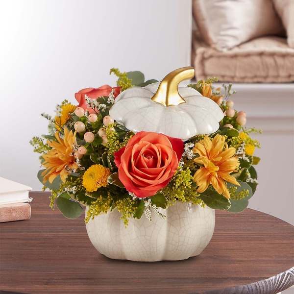 Pumpkin-shaped vase with orange roses and yellow flowers