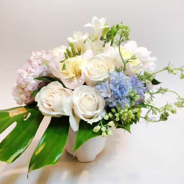 White roses and pastel flowers in a white vase
