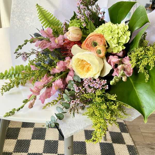 Mixed bouquet with pink and cream flowers in white paper