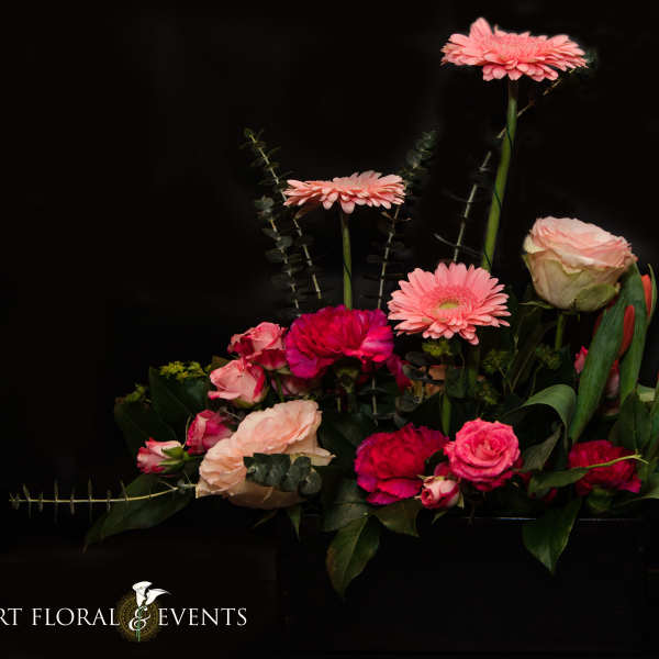 Pink and red mixed flower arrangement with tulips and roses