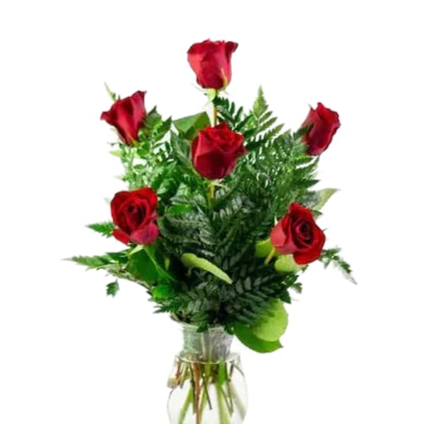 Red roses arranged in a clear glass vase