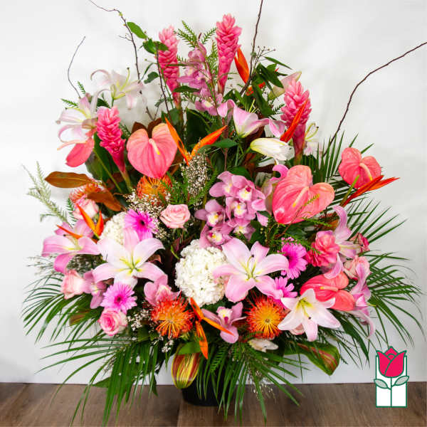 Large tropical bouquet with pink lilies, orchids, and anthuriums in a black vase