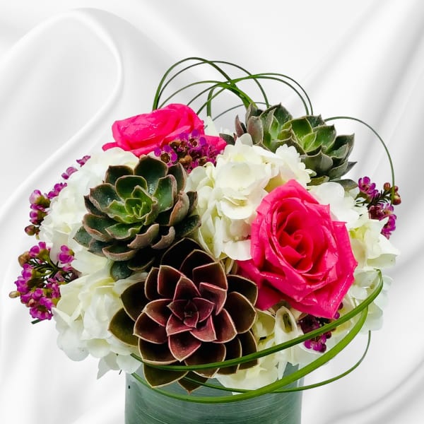 Pink roses and white hydrangeas with succulents in a glass vase