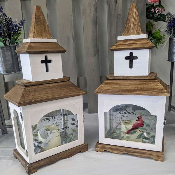 Two wooden memorial lanterns with cross cutouts and printed bird designs