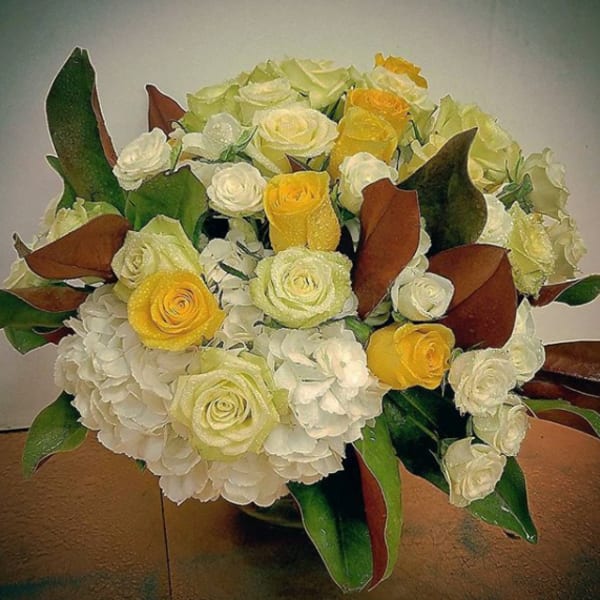 Bouquet of white and yellow roses with hydrangeas in a vase
