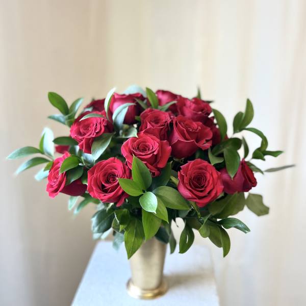 Bouquet of deep pink roses in a gold vase