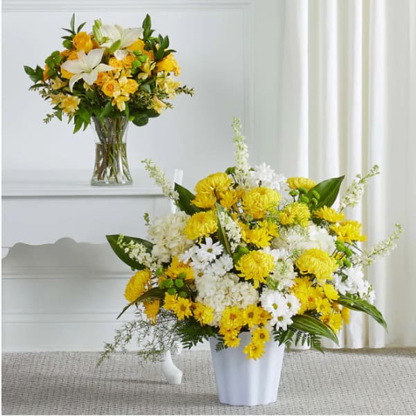 Yellow and white flower arrangements in a vase and white container