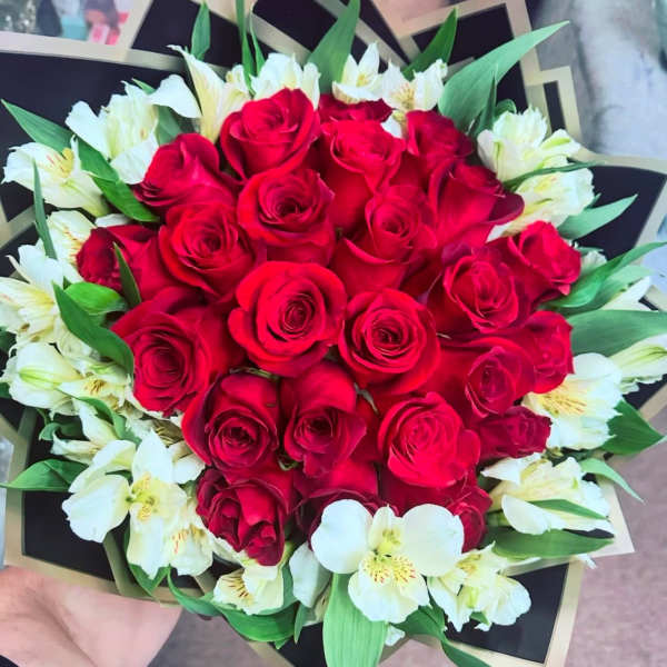 Bouquet of red roses and white alstroemeria with green leaves