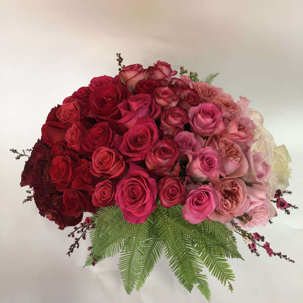 Large bouquet of red and pink roses with fern foliage