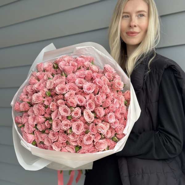 Large bouquet of pink roses wrapped in white paper