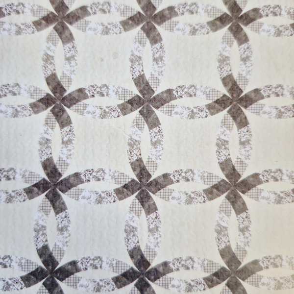 Patterned fabric with interlocking oval and bow shapes in muted brown and gray