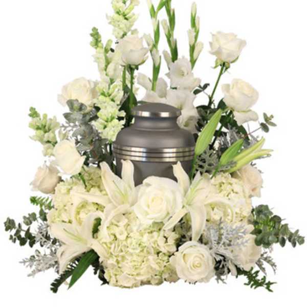 White funeral urn surrounded by white flowers and greenery