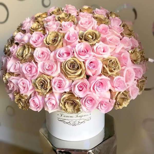 Round bouquet of pink and gold roses in a white hat box