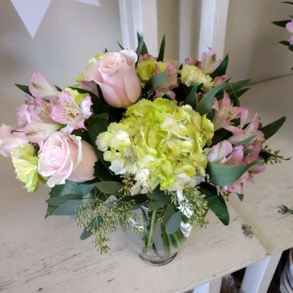 Bouquet of pale pink roses and lime hydrangea in a glass vase