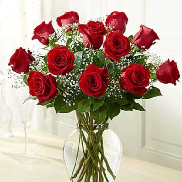Red roses arranged in a clear glass vase