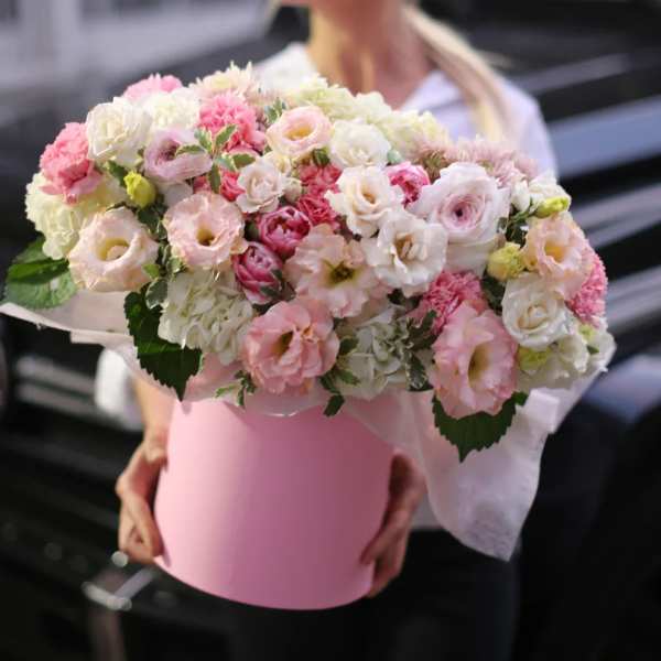 Pink and white flower arrangement in a pink hat box