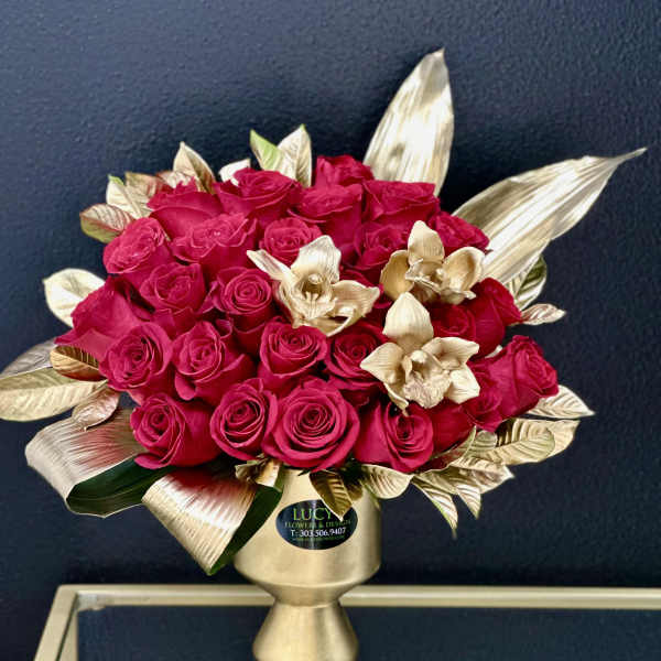 Bouquet of hot pink roses in a gold vase with metallic leaves