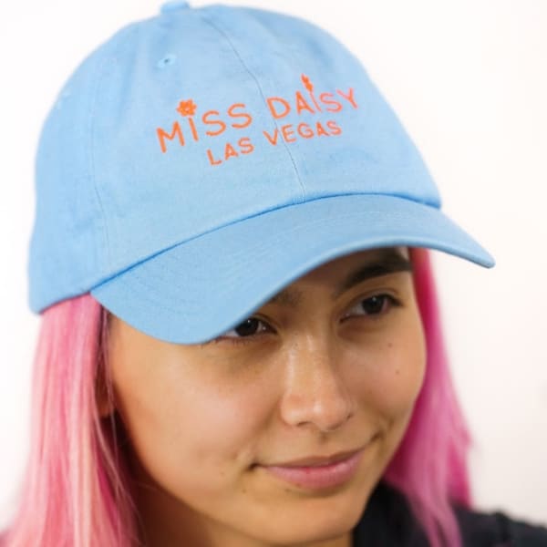 Person wearing a blue cap with orange text