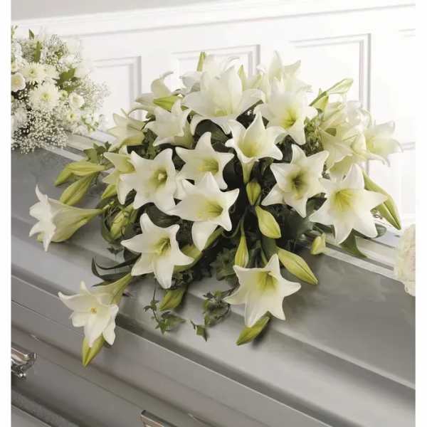 White lily funeral spray on a gray casket