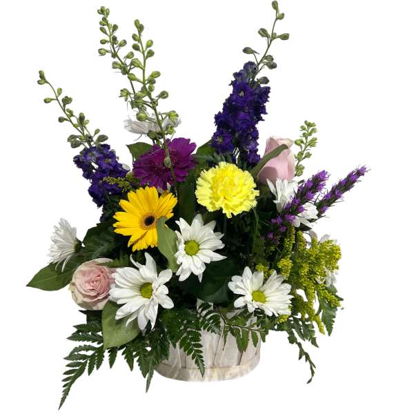 Mixed bouquet of daisies, roses, and purple blooms in a clear vase