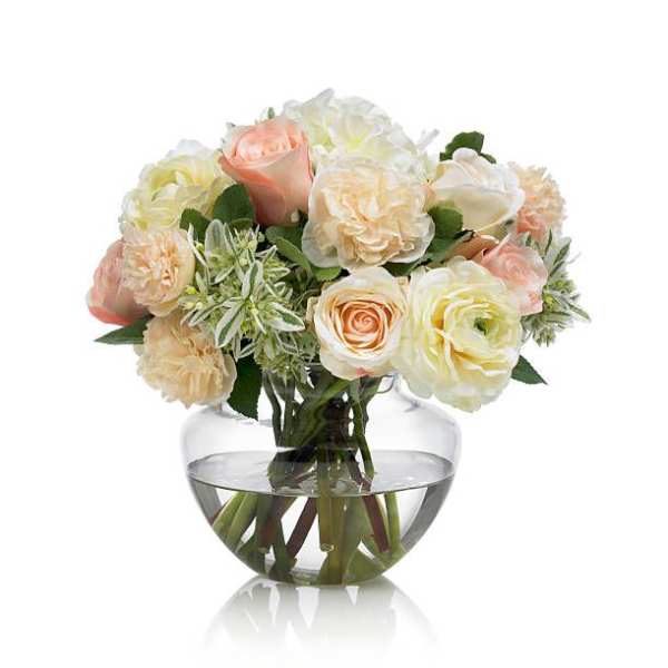 Bouquet of pale roses and cream flowers in a clear glass vase