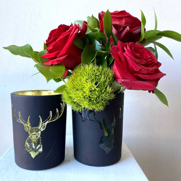 Red roses with green filler in black cups