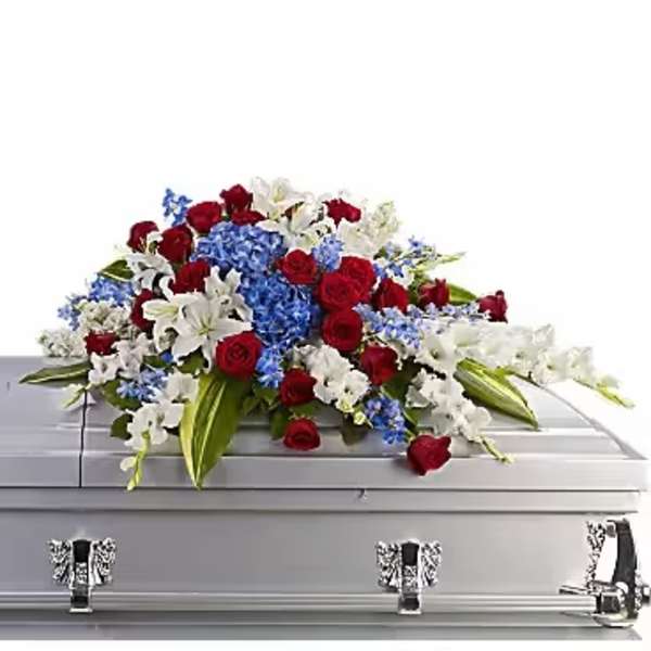 Red, white, and blue floral spray on a silver casket