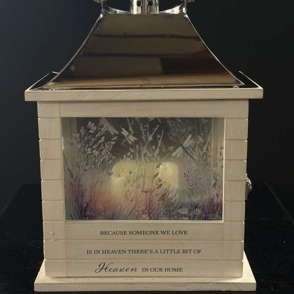 Decorative memorial lantern with a candle inside and floral artwork