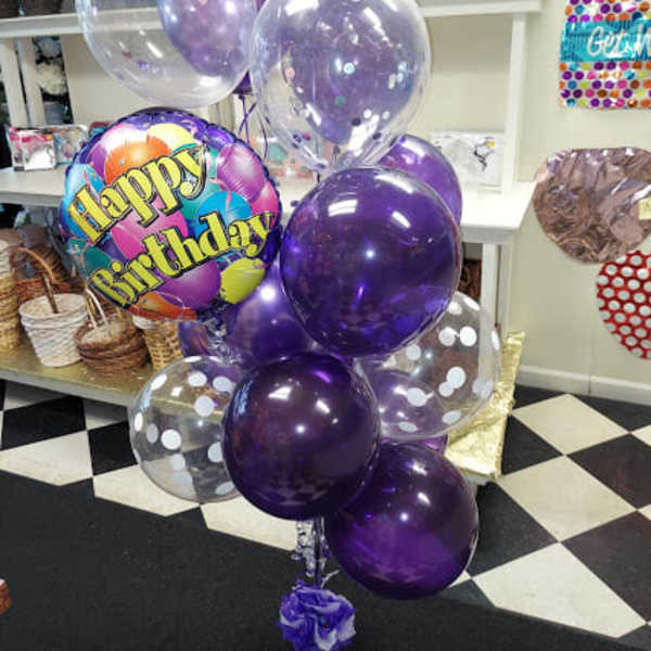 Cluster of purple and clear birthday balloons with a Happy Birthday balloon
