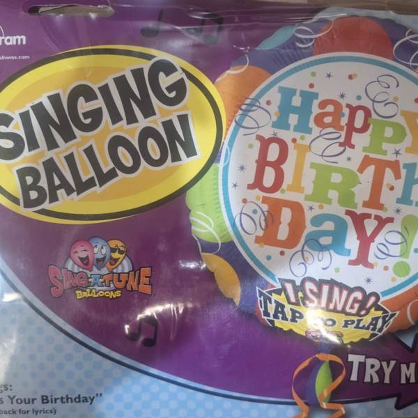 Packaged singing birthday balloon with colorful text and music notes
