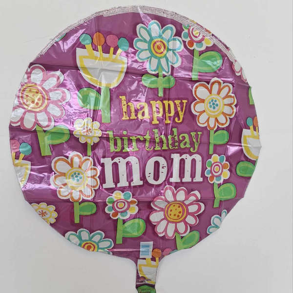 Round purple birthday balloon reading "happy birthday mom" with flower graphics