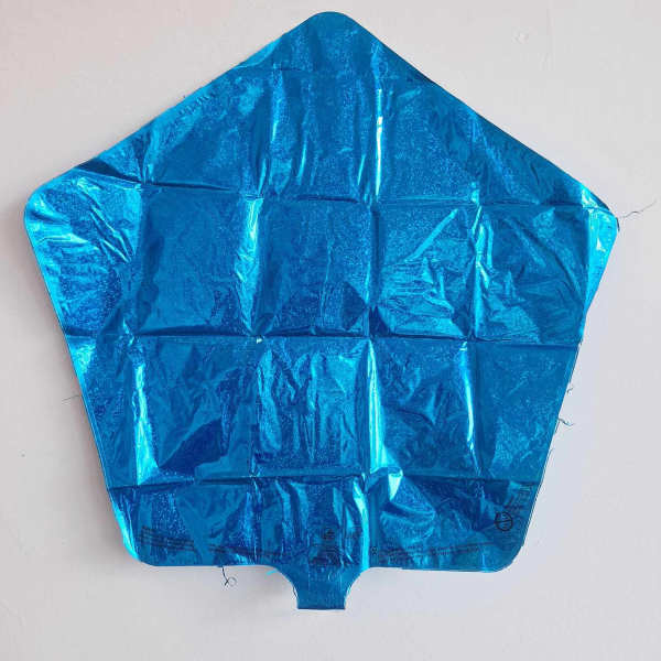 Blue metallic pentagon-shaped foil balloon against a white wall