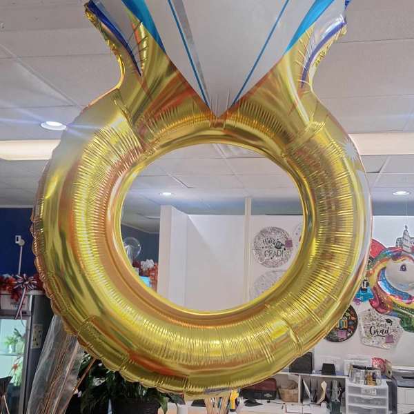 Large diamond ring-shaped foil balloon hanging indoors