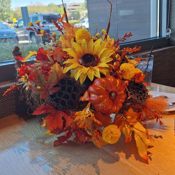 Autumn floral centerpiece with sunflowers, pumpkins, and fall leaves