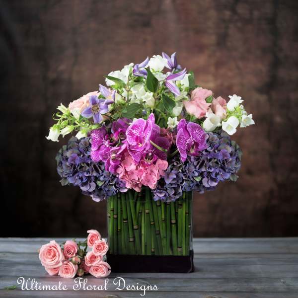 Mixed bouquet in a tall vase with pink, white, and purple flowers