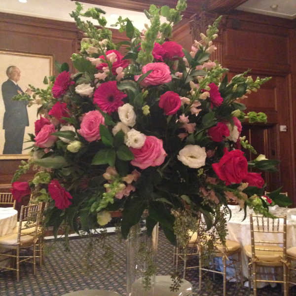 Large pink and white floral centerpiece in a clear vase