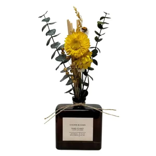 Yellow dried flower arrangement in a dark glass diffuser bottle