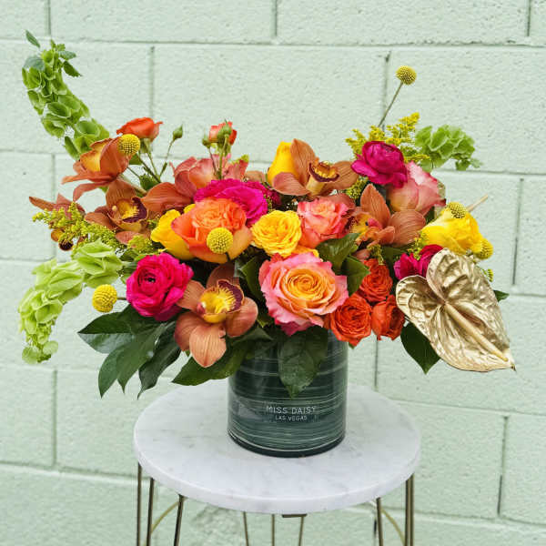 Bright mixed bouquet in a dark vase with orange, pink, and yellow blooms