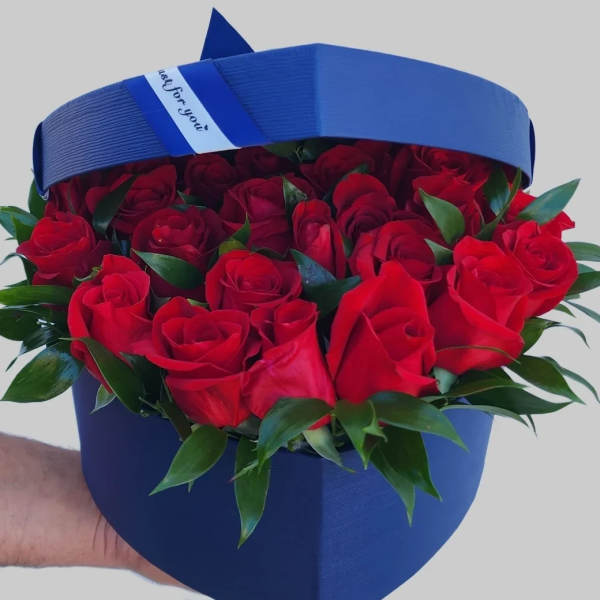 Red roses in a blue hatbox with a ribbon