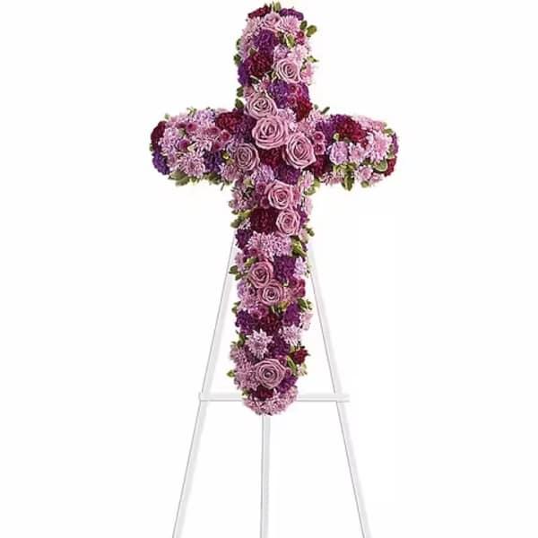 Purple and pink floral cross on a white stand