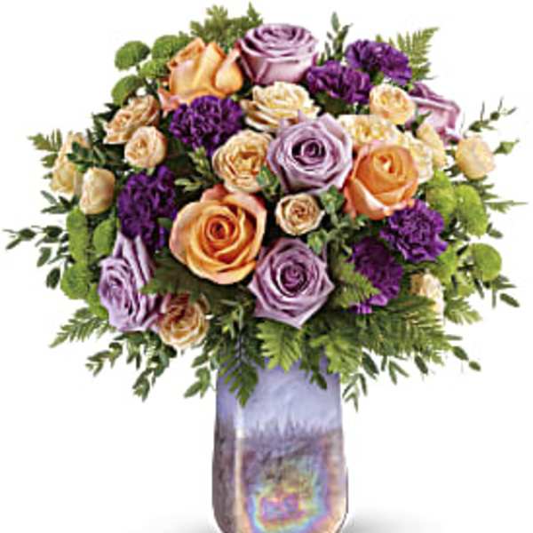 Bouquet of peach, lavender, and purple roses in a tall iridescent vase