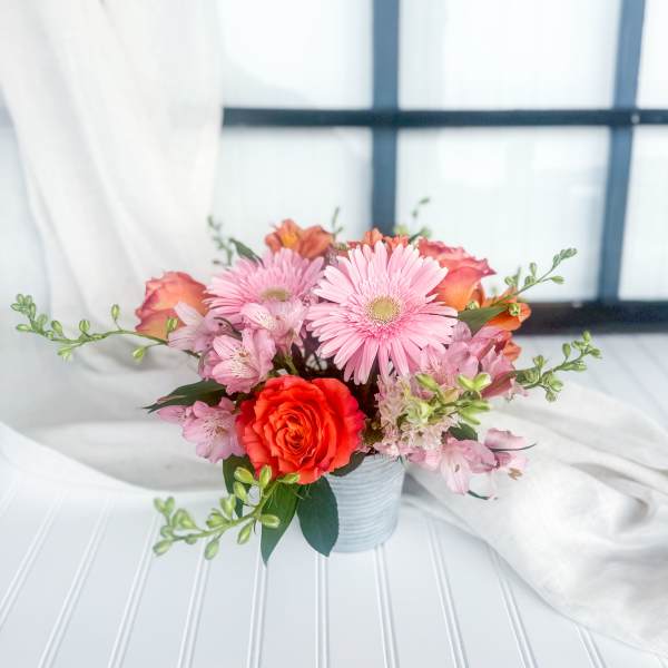 Pink and orange mixed bouquet in a small ribbed vase