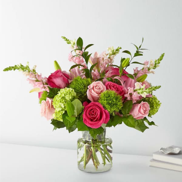 Pink roses and lilies in a clear glass vase