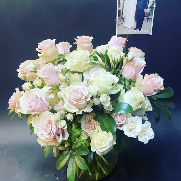 Bouquet of pale pink and white roses with a photo card
