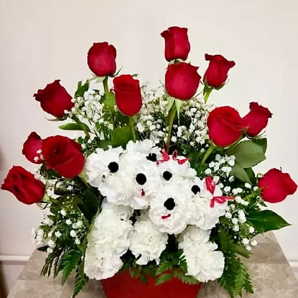 Red roses and white teddy bear flowers in a red container