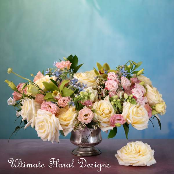 Large pastel bouquet of cream and pink roses in a silver vase