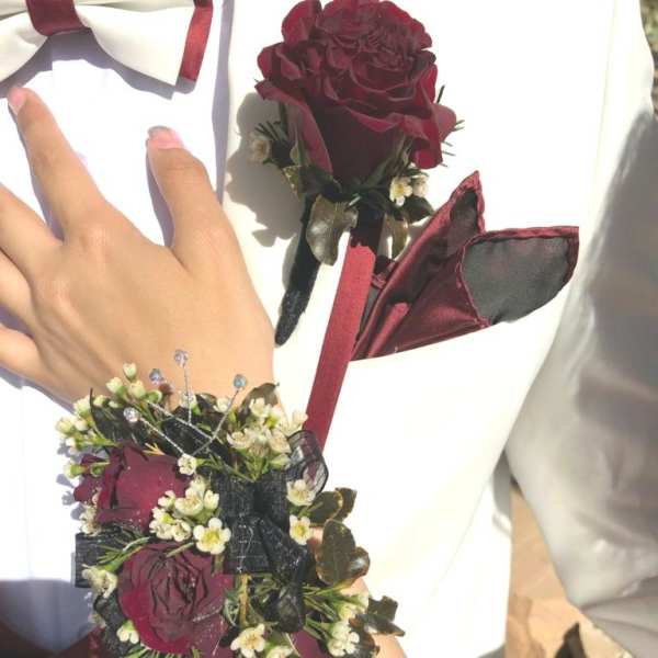 Boutonniere and wrist corsage with burgundy roses and white flowers