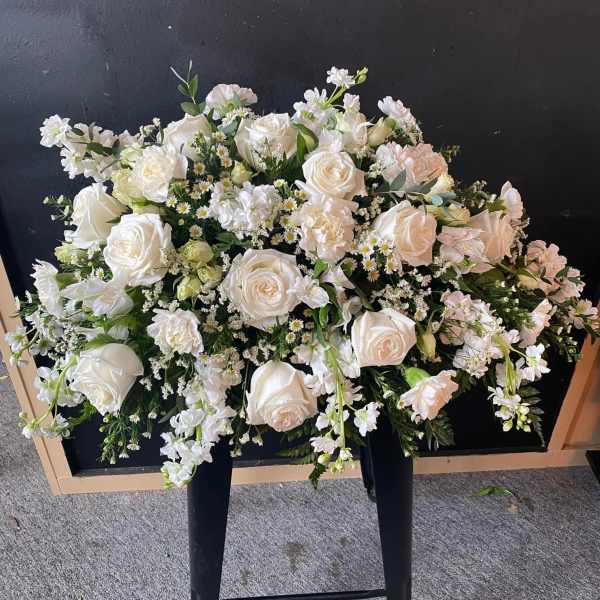 Large white floral spray with roses and small white blooms