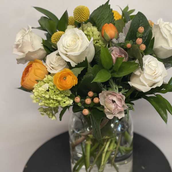 Mixed bouquet of white and orange flowers in a glass vase