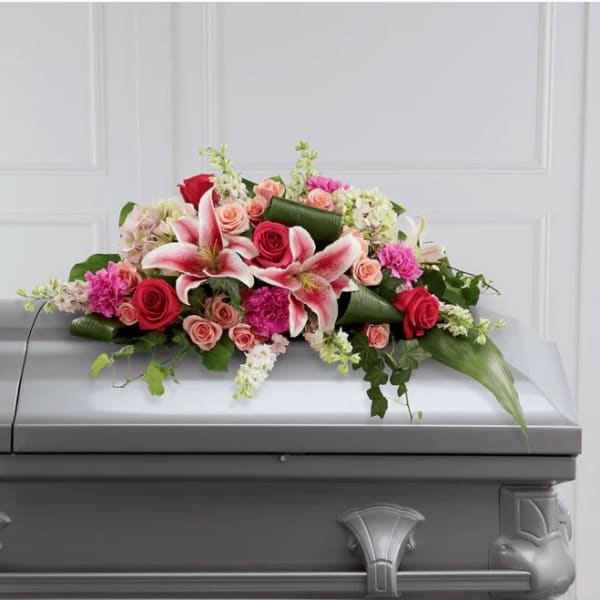 Pink and red floral casket spray with lilies and roses